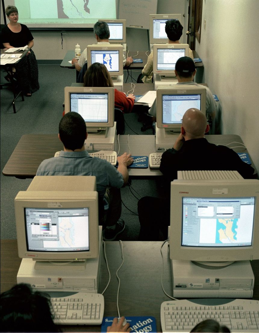 adults in a training classroom using computers