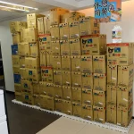 Stacked boxes of bottled water inside a convenience store - Bottled Water Brands Keep Winning Shelves Despite Plastic Fears