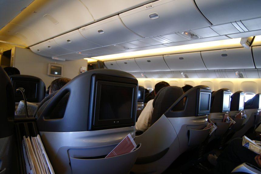 A business class airline seat in a modern aircraft cabin.