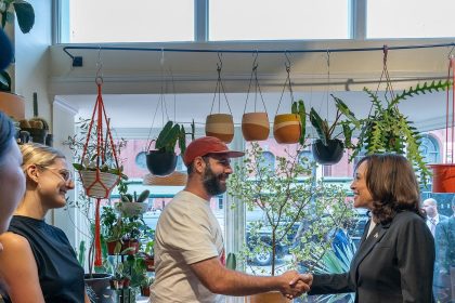 A small business owner serving a customer at a shop counter